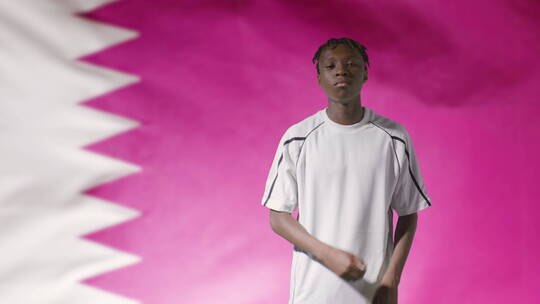 足球运动员在卡塔尔国旗前摆姿势