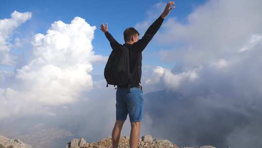 男人登顶张开双手握拳励志奋斗登山