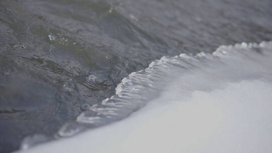寒冷感流动的水经过固定的冰岸4k50帧灰片