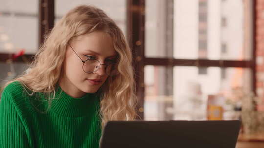 女学生在咖啡馆使用带免费Wifi的笔记本电脑漂亮女孩打字信息的肖像视频素材模板下载