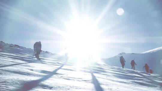 日光逆光下一群登山者在雪山山顶上行走视频素材模板下载