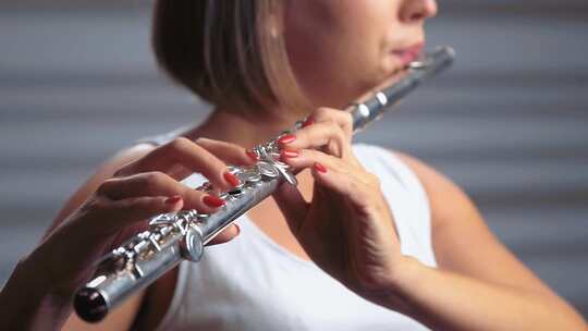 聚光灯下的职业音乐家女性长笛演奏。工作室