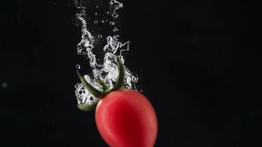 新鲜小番茄落入水中的特写慢镜头