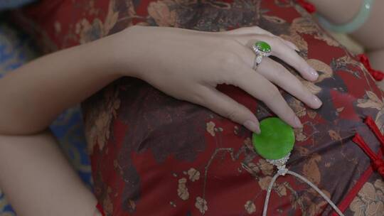 古典的美女穿旗袍佩戴珠宝翡翠手镯玉佩戒指