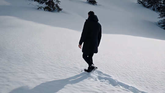 雪地男人独自行走背影