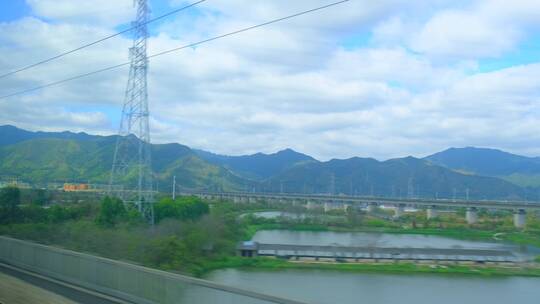 高速行驶中的高铁动车火车窗外远山田野风景