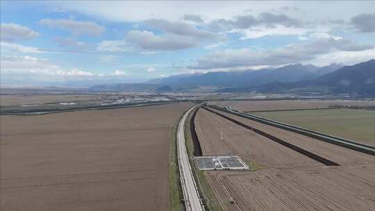 开阔田野上的道路及远方山峦景象