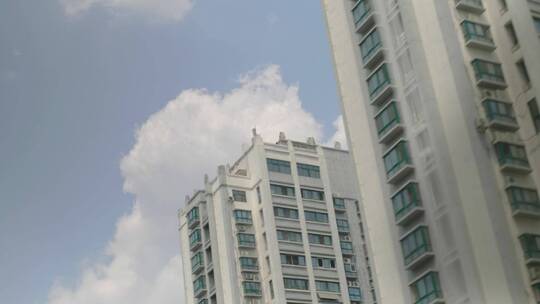 车内拍摄道路两侧的住宅建筑和蓝天白云