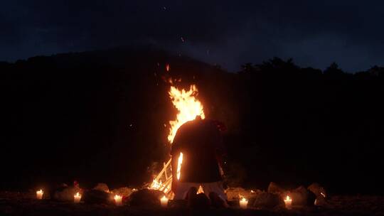 夜幕下进行篝火祈福的人