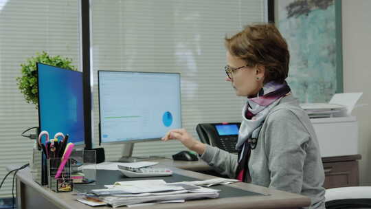 女会计坐在办公桌前用电脑做数据分析检查统计研究工作日