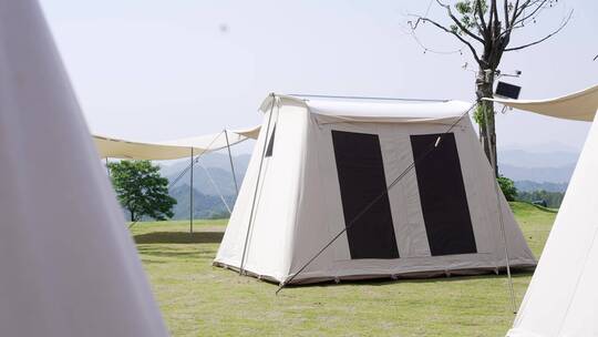 阳光下草地上露营的帐篷航拍