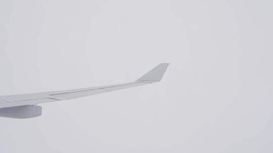飞机上看窗外机翼云雾里穿梭飞行