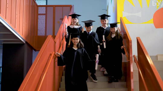 学生拿着毕业文凭跑下楼梯视频素材模板下载