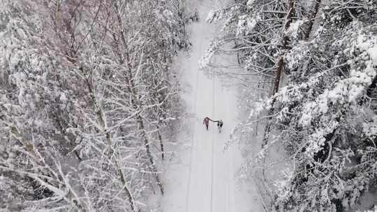 一对夫妇在雪地上行走的无人机镜头