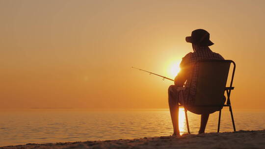 男士坐在海滩上钓鱼