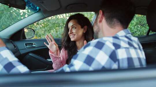 积极的夫妇坐在车里慢动作说话