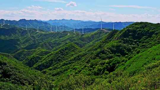 夏季绿色高山蓝天白云与风力发电机组