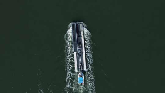 运送大型浮桥的小船经过河道上的航标。高无人机视图。