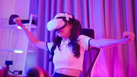 亚洲年轻的电子竞技女玩家使用科技VR眼镜玩游戏。