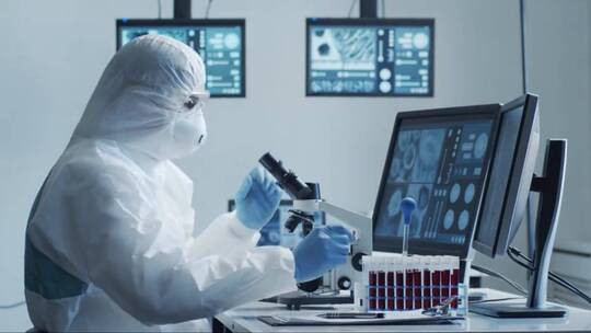 穿着防护服和面具的科学家在实验室工作