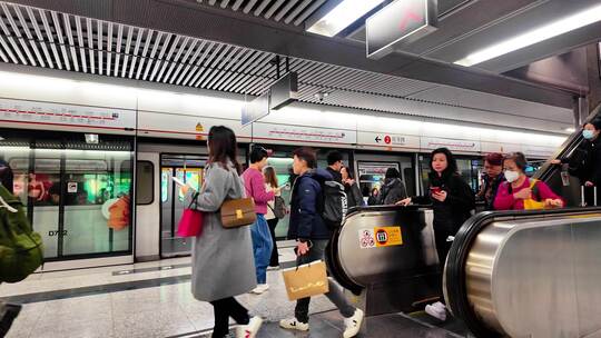 香港地铁站内人们乘电梯上下行走的场景