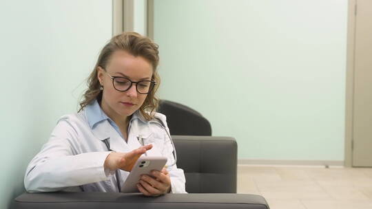 诊所里使用手机的女医生视频素材模板下载