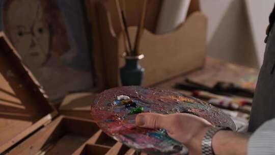 一个在调色板上混合油漆的人