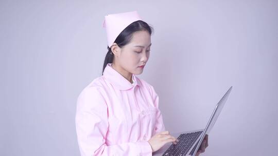 年轻女性医护形象手持笔记本电脑办公视频素材模板下载
