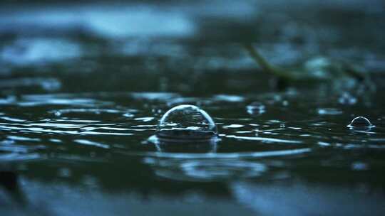 阴沉天气下雨天雨滴落下冒泡特写