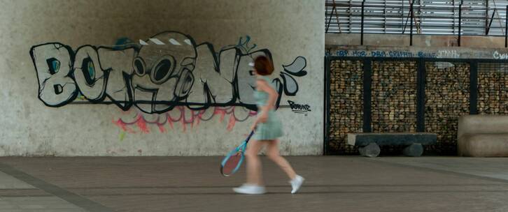 公园大桥下打壁球网球的女人