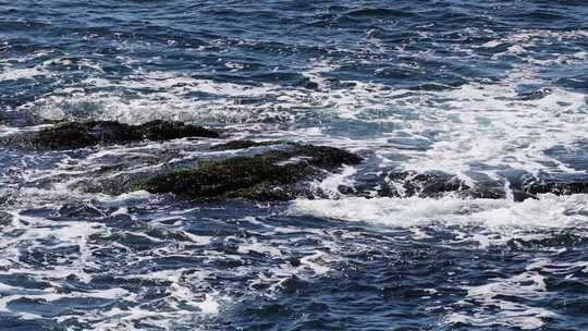 晴朗海面海浪拍打礁石蓝色海洋浪花慢镜头