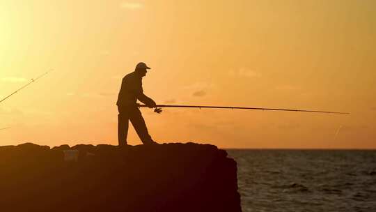 男人在夕阳下的海边钓鱼视频素材模板下载