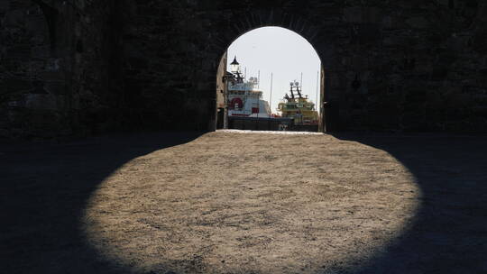 从古堡垒墙的拱门看海港