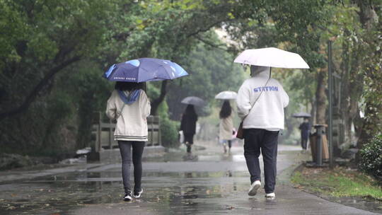 下雨天公园里的行人背影