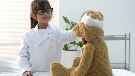 装扮成医生的小女孩给玩具小熊看病视频素材模板下载