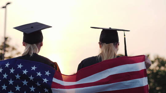 毕业生举起手拿着美国国旗