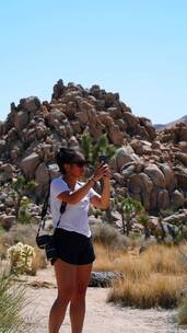女人用手机拍遍沙漠周围