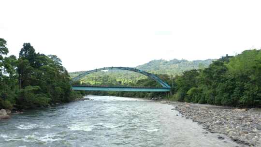 鸟瞰宽阔的河流，有一座金属桁架桥，经过桥
