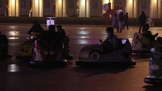 新年广场的夜晚玩碰碰车游乐的人们