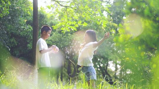 夏天孩子们在公园玩耍吹泡泡慢镜头视频