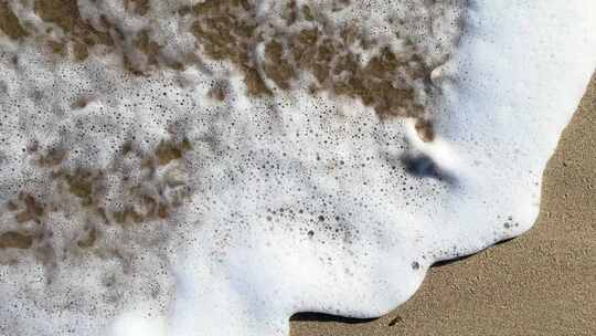 海浪冲走沙滩上的两个脚印