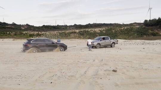 小汽车陷入沙滩泥沙中救援车绞盘脱困视频
