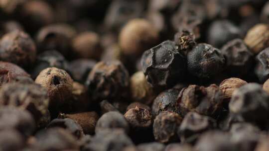 干黑胡椒粒掉落，胡椒香料种子的极端特写