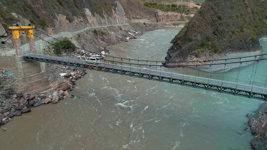 4k西藏江河视频航拍藏区江上的铁索桥和车辆