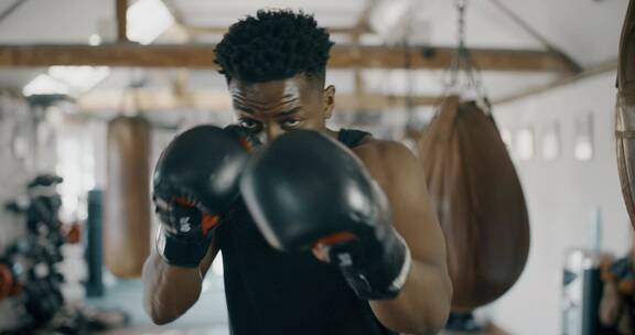 健身房的黑人用拳击手冲向相机