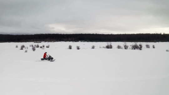 无人机拍摄了两个人在田野上骑雪地摩托。