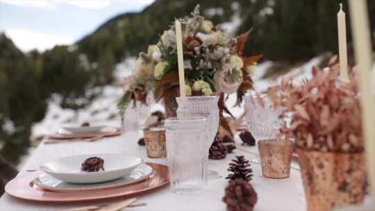 山中央浪漫的婚宴桌。冬季婚礼装饰。餐桌装