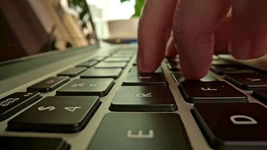 特写手指在笔记本电脑的键盘上打字1_4K