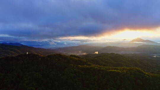 夕阳透过云层染红了山林