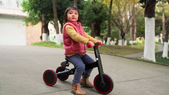 公园里骑三轮车的小女孩